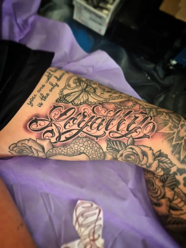 'Loyalty' script with roses by Chris Carp at Heart & Sword Tattoo