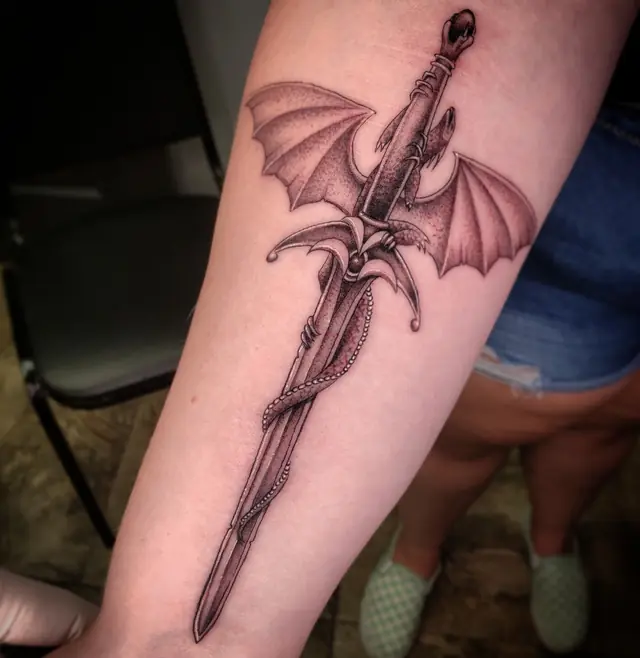 Fine line dragon wrapped around a sword by Chris Carp at Heart & Sword Tattoo