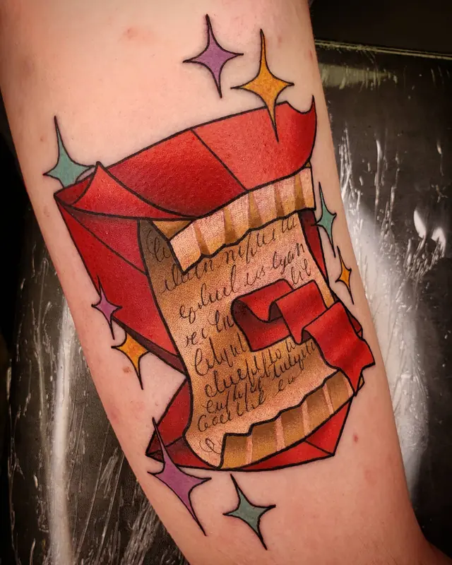 Neo-traditional red scroll letter tattoo with sparkles by Chris Carp at Heart & Sword Tattoo