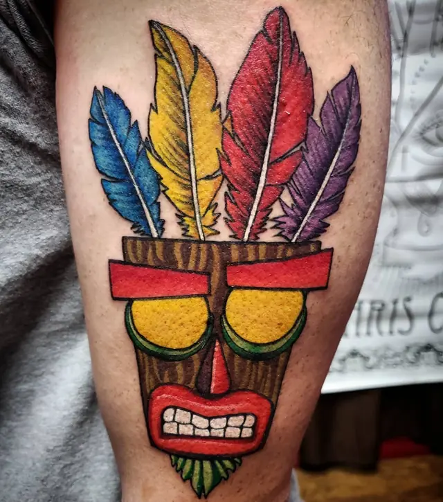 Video game tiki mask with feathers by Chris Carp at Heart & Sword Tattoo