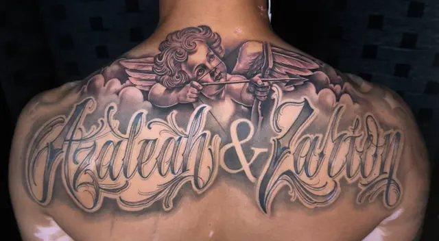 Custom script lettering with cherub on upper back by Johnny at Heart & Sword Tattoo